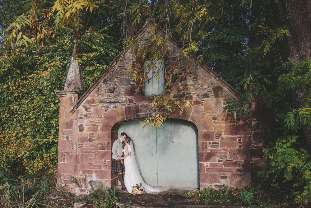 Newlyweds kiss at the Boathouse at Fyvie castle captured by Aberdeen wedding photographer