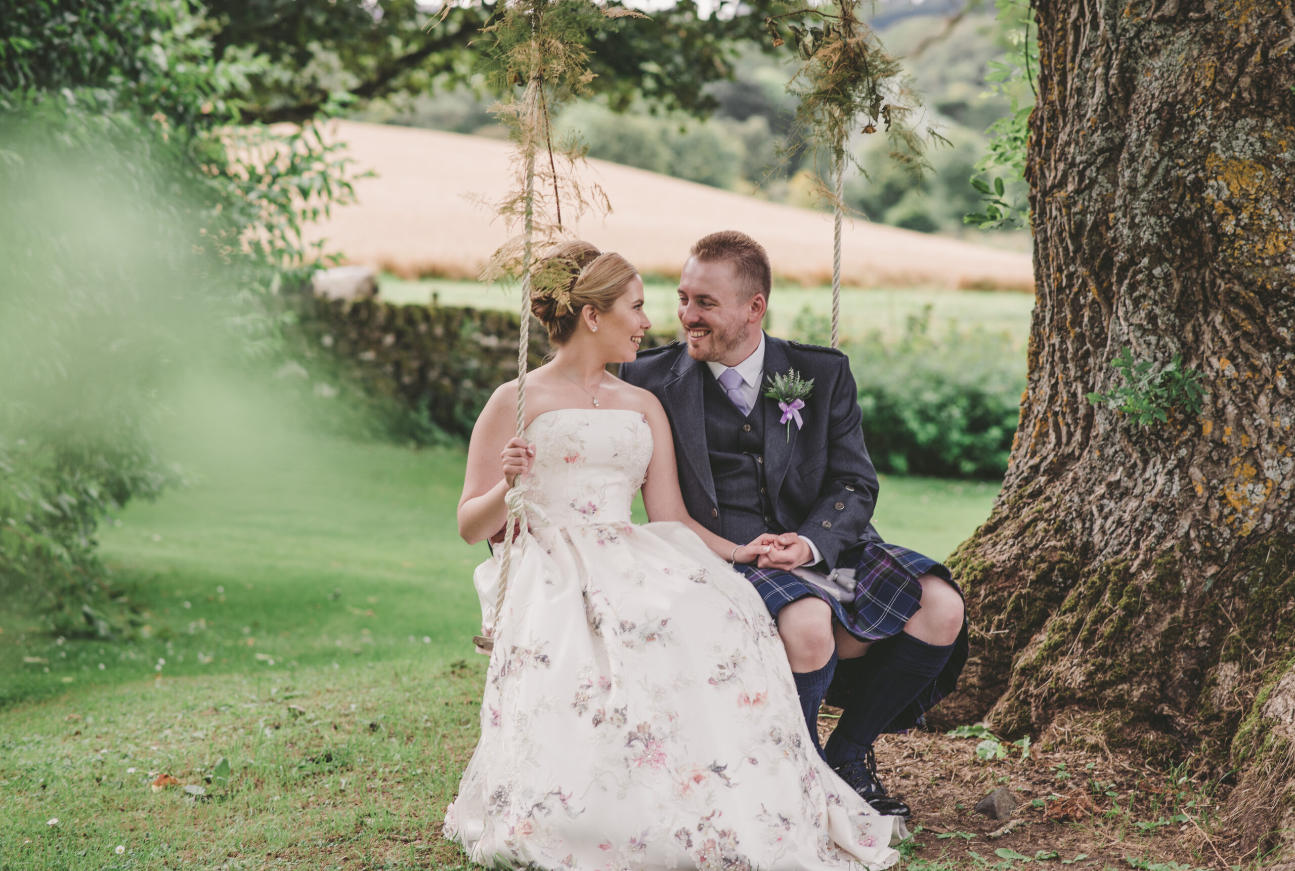 A newlywed couple sit on a swing in the garden at Aswanley, Aberdeen